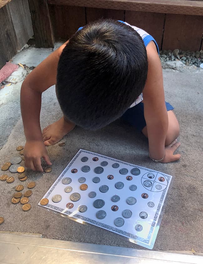A child engaged with a coin-matching activity.